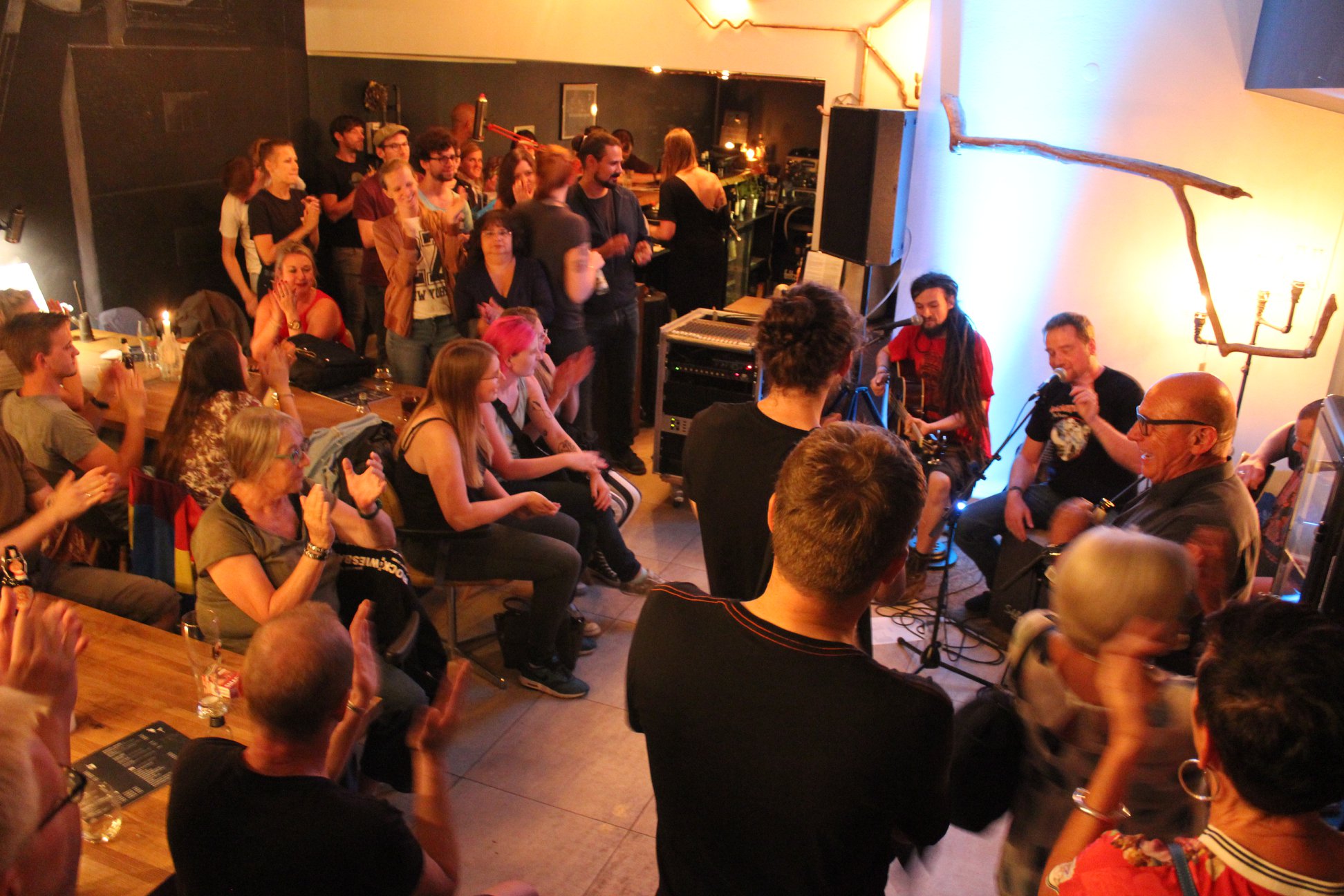 Acoustic-Tour Westend: Band spielt unplugged in einem kleinen Raum, das Publikum klatscht mit